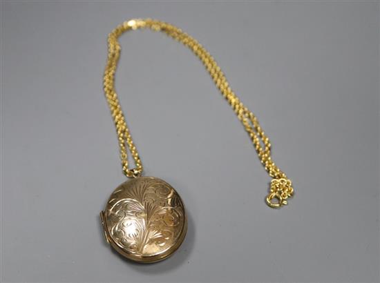 A 9ct engraved gold enclosed locket on 9ct gold trace link chain, gross 24.5g.
